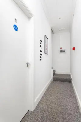 an empty hallway with white walls and a door at The Wavertree Rooms - Air Host & Stay - 6 Bedrooms in Liverpool