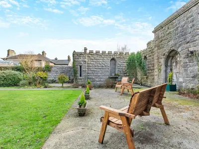 a garden with two benches and a stone building at Uk46866 - Hawkshead in Ulverston