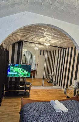 a bedroom with a bed and a flat screen tv at Ritchie Guest House in Wigan
