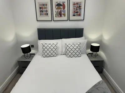 a bedroom with a large white bed with two lamps at Harrington Street Apartments Liverpool by Beehosting in Liverpool