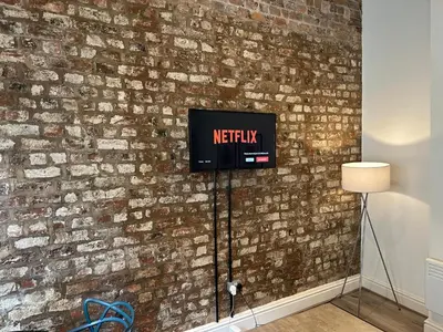 a television on top of a brick wall at Harrington Street Apartments Liverpool by Beehosting in Liverpool