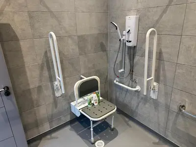 a bathroom with a shower with a chair in it at Harrington Street Apartments Liverpool by Beehosting in Liverpool