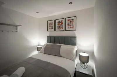 a bedroom with a bed and three pictures on the wall at Harrington Street Apartments Liverpool by Beehosting in Liverpool