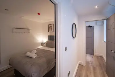 a small bedroom with a bed and a mirror at Harrington Street Apartments Liverpool by Beehosting in Liverpool