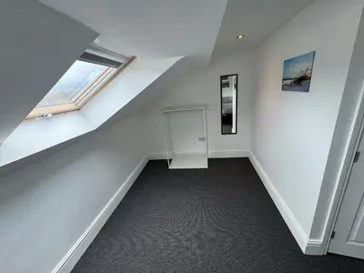 an attic room with a staircase and a window at Theo apartment 150 meters from the winter gardens large groups welcome in Blackpool