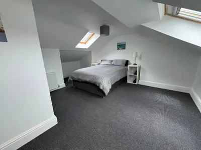 a white bedroom with a bed and a window at Theo apartment 150 meters from the winter gardens large groups welcome in Blackpool