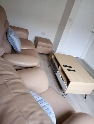 a living room with a couch and a wooden table at Mesnes Place in Wigan
