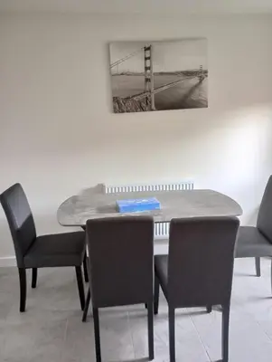 a dining room table with chairs and a picture of a bridge at Mesnes Place in Wigan