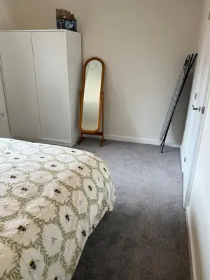 a bedroom with a bed and a dresser and a mirror at Mesnes Place in Wigan