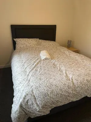 a white towel sitting on top of a bed at Mesnes Place in Wigan