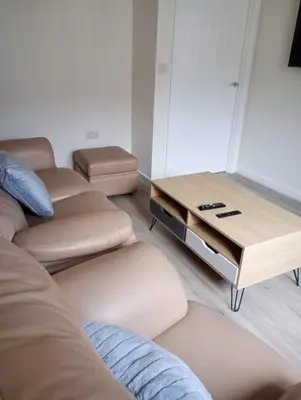 a living room with couches and a coffee table at Mesnes Place in Wigan