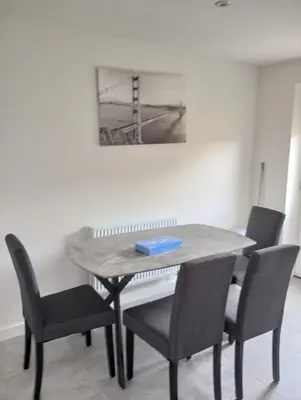 a dining room table with chairs and a book on it at Mesnes Place in Wigan