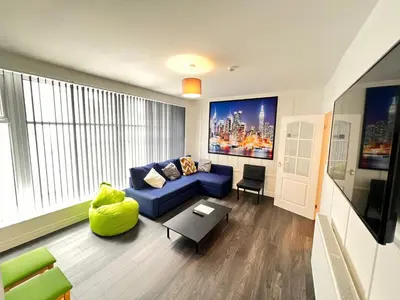 a living room with a blue couch and a table at The Brooklyn loft apartment in Blackpool