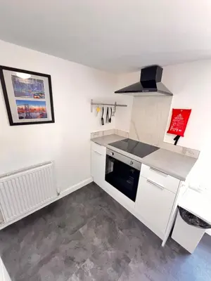 a kitchen with white cabinets and a stove top oven at The Brooklyn loft apartment in Blackpool