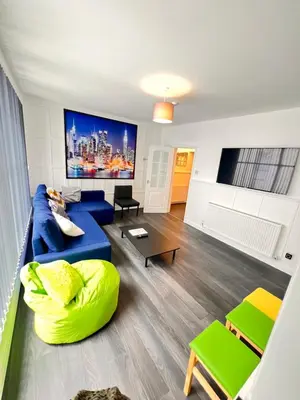 a living room with a blue couch and a table at The Brooklyn loft apartment in Blackpool