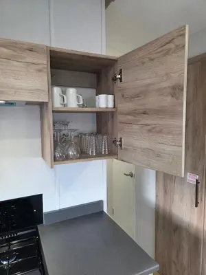 a kitchen with white cabinets and wooden doors at 8 Berth Caravan Haven Marton Mere in Blackpool
