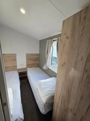 a small room with two beds and a window at 8 Berth Caravan Haven Marton Mere in Blackpool