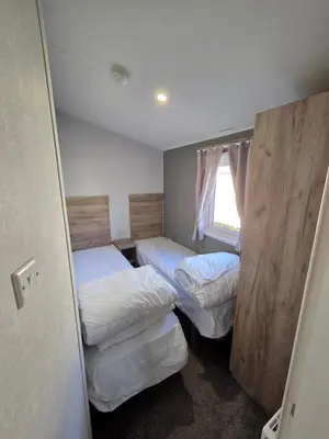 a small room with two beds and a window at 8 Berth Caravan Haven Marton Mere in Blackpool