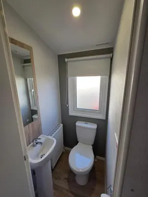 a small bathroom with a toilet and a sink at 8 Berth Caravan Haven Marton Mere in Blackpool