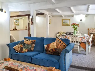 a blue couch in a living room with a table at Seagull Cottage in Heysham