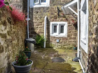 an entrance to a stone house with potted plants at Seagull Cottage in Heysham