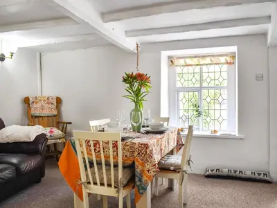a dining room with a table and chairs and a couch at Seagull Cottage in Heysham