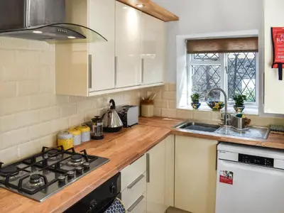 a kitchen with a stove top oven next to a sink at Seagull Cottage in Heysham