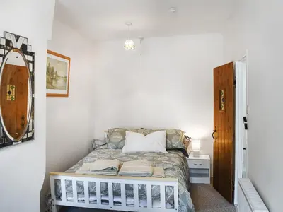 a bedroom with a bed in a white room at Seagull Cottage in Heysham