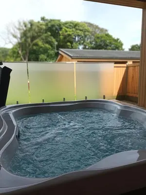 a hot tub in a backyard with a window at Nash - Bowland Retreat Lodges Clitheroe, Ribble Valley, Lancashire in Clitheroe