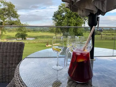 two glasses of wine on a table with a view at Nash - Bowland Retreat Lodges Clitheroe, Ribble Valley, Lancashire in Clitheroe