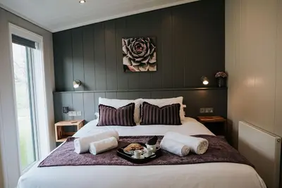 a bedroom with a large bed with a tray of animals on it at Nash - Bowland Retreat Lodges Clitheroe, Ribble Valley, Lancashire in Clitheroe