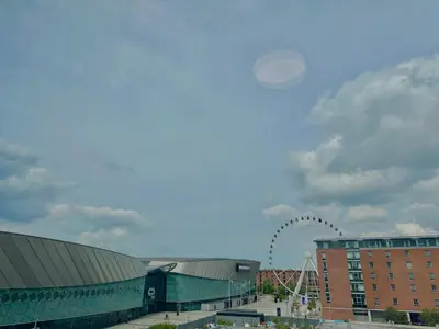 a frisbee is flying in the sky over a city at Monarchs Quay Arena Apartments by Happy Days in Liverpool