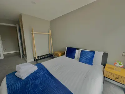 a bedroom with a large bed with blue pillows at Monarchs Quay Arena Apartments by Happy Days in Liverpool