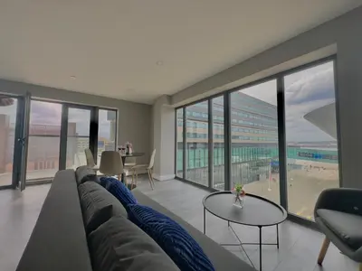 a living room with a couch and a table at Monarchs Quay Arena Apartments by Happy Days in Liverpool