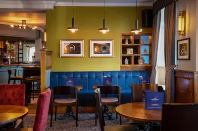 a restaurant with tables and chairs and green walls at The Highlands, Bispham in Blackpool