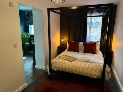 a bedroom with a canopy bed with a book on it at Clock Tower Apartments 1 in Morecambe