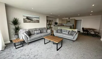 a living room with two couches and a table at Clock Tower Apartments 1 in Morecambe