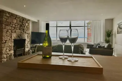 two wine glasses and a bottle on a table at Clock Tower Apartments 1 in Morecambe