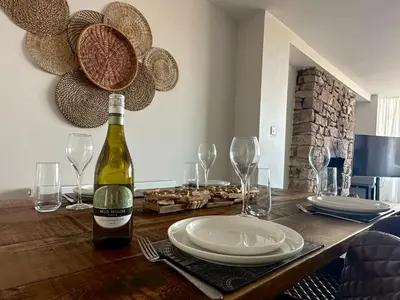 a bottle of wine on a wooden table with plates and glasses at Clock Tower Apartments 1 in Morecambe