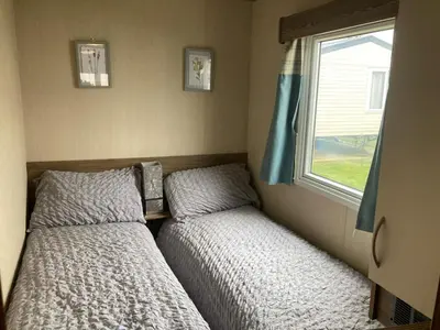 two beds in a small room with a window at A fully equiped caravan Marton mere haven in Blackpool