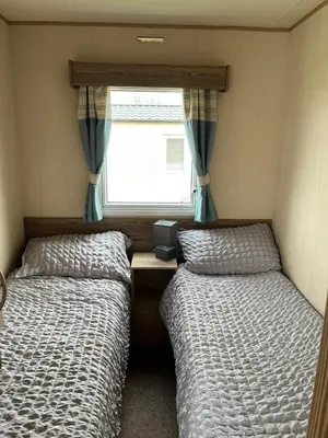 two beds in a small room with a window at A fully equiped caravan Marton mere haven in Blackpool