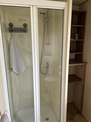 a shower with a glass door in a bathroom at A fully equiped caravan Marton mere haven in Blackpool