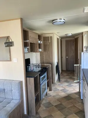 a kitchen with wooden cabinets and a counter top at A fully equiped caravan Marton mere haven in Blackpool