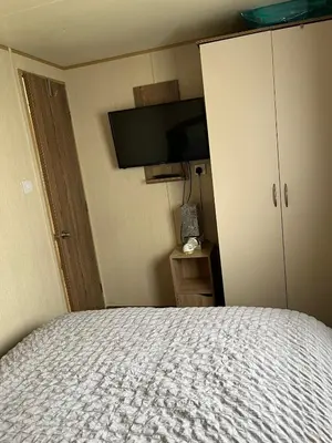 a bedroom with a bed and a tv on the wall at A fully equiped caravan Marton mere haven in Blackpool