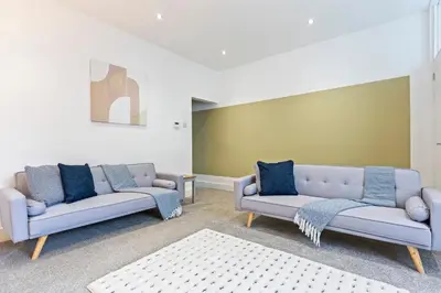 a living room with two couches and a rug at Stylish House - Sleeps 7 - Free Parking, Fast WiFi and Smart TV - Contractors, Groups and Long Stays Welcome by Yoko Property in Wigan