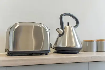 a toaster and a tea kettle on a counter at Stylish House - Sleeps 7 - Free Parking, Fast WiFi and Smart TV - Contractors, Groups and Long Stays Welcome by Yoko Property in Wigan