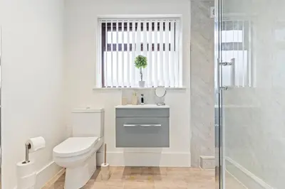 a bathroom with a toilet and a sink and a shower at Stylish House - Sleeps 7 - Free Parking, Fast WiFi and Smart TV - Contractors, Groups and Long Stays Welcome by Yoko Property in Wigan
