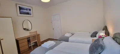 a bedroom with two beds and a desk and a mirror at A nice home in Liverpool in Liverpool