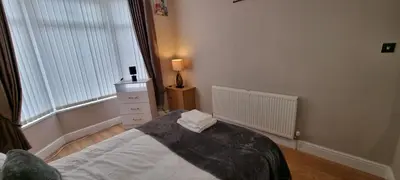 a bedroom with a bed and a dresser and a window at A nice home in Liverpool in Liverpool