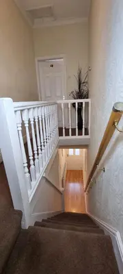 a white stairway with a potted plant in a room at A nice home in Liverpool in Liverpool